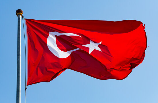 Turkish flag hang on a pole, blue sky on background