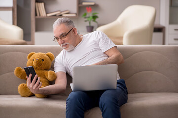 Old man with toy bear at home