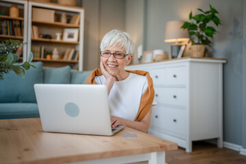 Senior caucasian woman use laptop computer at home for work - Powered by Adobe