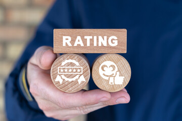 Man holding wooden blocks sees text: RATING. Business concept of five star rating, feedback, level...