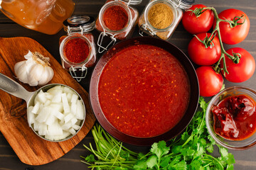 Homemade Sofrito Surrounded by Spices and Vegetables: A bowl of sofritas sauce surrounded by fresh...