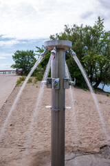 fresh water  flows from a shower stand on a public beach on toronto's center island shot in summer