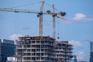 Gordijnen tall building construction site with active cranes shot in toronto in summer © Michael Connor Photo