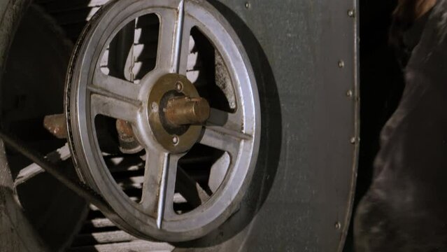 A close-up of a male hand professionally cleaning the motors and air conditioning unit, using a vacuum cleaner to move the refrigerant and exhaust plenum fan - black and white 4k UHD footage