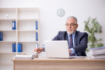 Old male employee working in the office