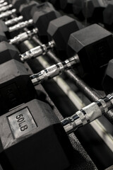 Closeup of a rack of hexagonal dumbbells at a gym or fitness club. Workout and training concept.