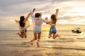 Group of Young Asian woman friends walking and playing together in the sea at tropical island beach...