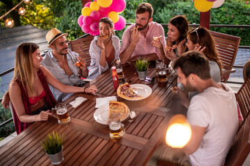Group of friends eat pizza together