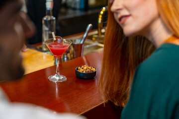 Professional Asian man bartender preparing and serving cocktail drink to customer on bar counter at nightclub. Barman making mixed alcoholic drink for celebrating holiday party at restaurant bar.