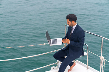 Confidence businessman working on laptop computer and talking on mobile phone for global corporate...