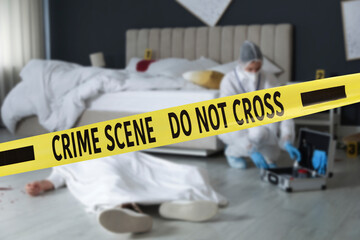 Yellow tape blocking way to crime scene. Criminologist working in room