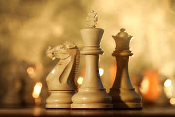 Wooden king, queen and knight on chessboard in smoke
