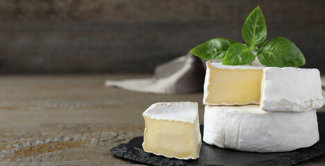 Tasty brie cheese on wooden table, space for text. Banner design