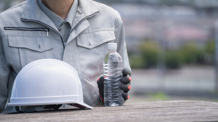 ヘルメットとペットボトルの水｜建設業・熱中症対策　イメージ