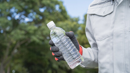 作業服の男性とペットボトルの水｜建設業・熱中症対策　イメージ