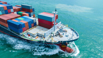 Aerial side view of cargo ship carrying container and running for export cargo yard port to custom...