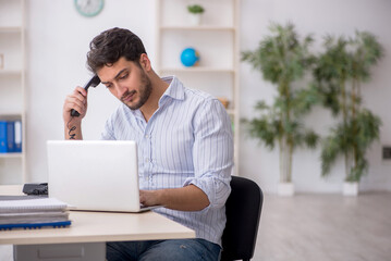 Young male employee working in the office