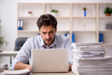 Young male employee and too much work in the office