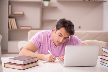 Young male student preparing for exams at home