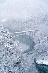 Drone Aerial view Landscape of Railway bridge between the mountain over the river in snow day. Pine...