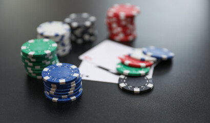 High-stakes Texas Hold'em poker chips and cards symbolize risk, chance, and adrenaline in gambling at the casino. Bet for fortunes