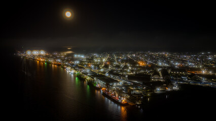 Fototapeta na wymiar Night aerial view of Porto de Paranaguá with part of the city and the full moon in the sky, Paranaguá, Paraná, Brazil.