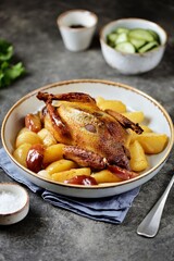 Baked pigeon with apples, potatoes and onions