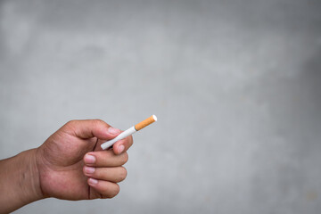 Hand holding cigarette on the blur background