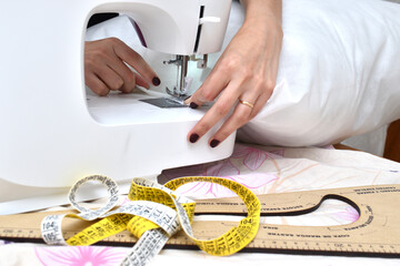 woman using a sewing machine sewing fabrics