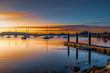 Sunrise at the jetty with high cloud and boats on the water