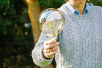 Illuminating Ideas: A woman gracefully holds a light bulb, representing the spark of creativity and bright concepts.