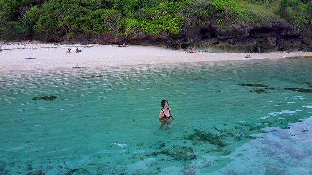 A Woman On The Turquoise Ocean Of Gunung Payung Beach In Bali, Indonesia. Aerial Shot