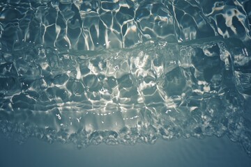 Blue water with ripples on the surface. Defocus blurred transparent blue colored clear calm water surface texture with splashes and bubbles. Water waves with shining pattern texture background.