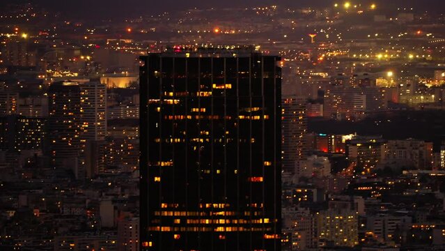 Cityscape view from above of the Montparnasse skyline, illuminated in the night, in Paris, France