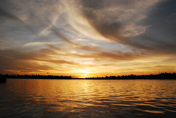 Scenic view dramatic beautiful sunset sky. Natural Sunset Sunrise on meadow silhouette shadow dark land. Vibrant dramatic sky on sunset, dawn, sunrise in Countryside. Landscape Colorful Sky At Sunset