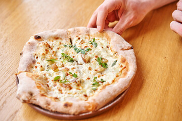 one people takes slices of pizza. Neapolitan pizza from a wood-fired oven. Pizza is on the plate. Pizza with pear and gorgonzola. Fast delivery of food. 