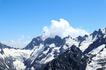 Obraz premium Mountain landscape: white weightless clouds among the mountains on a summer sunny day, close-up