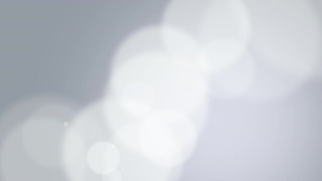 A large white circle stands out in the center against a captivating gray background with shimmering bokeh effects, evoking elegance and deep contemplation