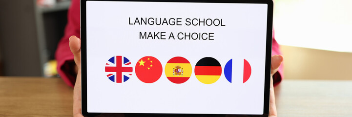 Woman holds tablet with text language school and offers to choose foreign language to study.