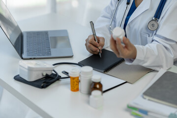 Senior female medical staff in the clinic wearing a doctor's white coat is examining Record patient medication information Medical concept, research, guideline, treatment, medicine