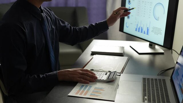 Asian businessman working in the office, calculating financial reports, organizing paperwork using a laptop and calculator as an aid. management concept accounting.