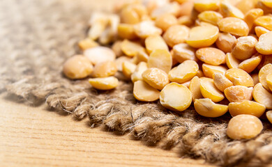 Peas on top of a jute fabric on wood surface
