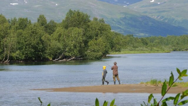 Fishermen trying to catch wild fish in Sweden river, distance view