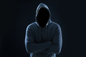 Anonymous man in hood on black background