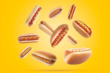 Many tasty hot dogs falling on golden background