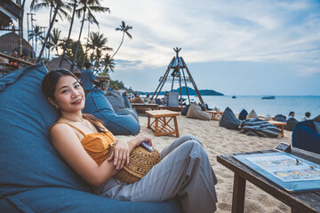Traveler asian woman with mobile phone travel in beach club cafe Koh Kamui Thailand
