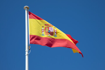spain spanish country flag on top of the mast in the wind and blue sky