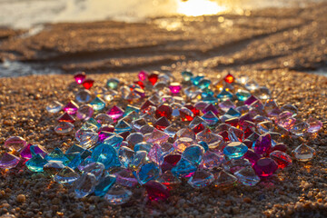 Colorful diamonds scattered on the beach The sun glistened off the facets of the precious stones, .creating a beautiful contrast with the white sand.colorful gemstones on the beach ..