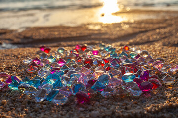 Colorful diamonds scattered on the beach The sun glistened off the facets of the precious stones,...