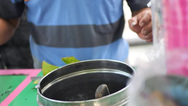 Es Puter Solo Seller serving customer. Traditional Javanese coconut ice cream sundae, with toppings of pandan noodle jelly and jackfruit.